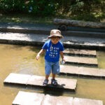 boy crossing a pond