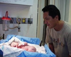 father looking at newborn baby