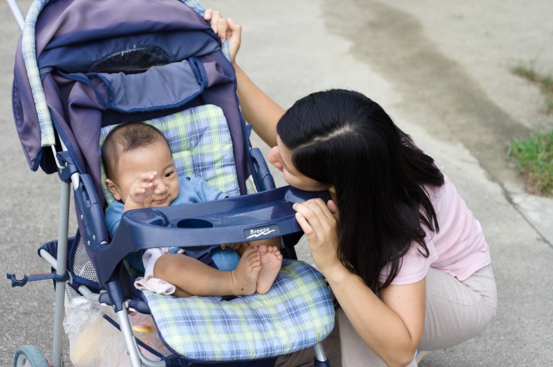 mother looking at her baby sitting in stroller